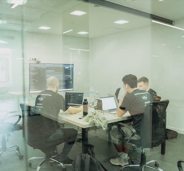 El equipo trabajando tras una pared de cristal, con las pantallas encendidas