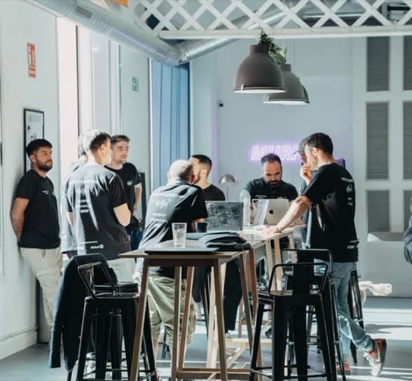 El equipo de pie alrededor de una pantalla compartida